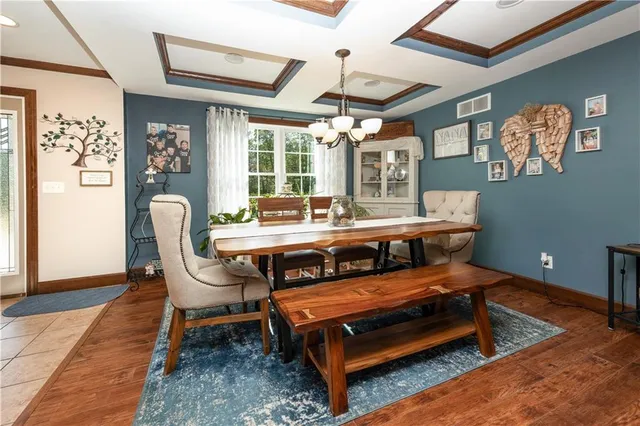 a living room with furniture a chandelier and a dining table with wooden floor