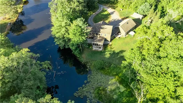 an aerial view of residential house with outdoor space and trees all around