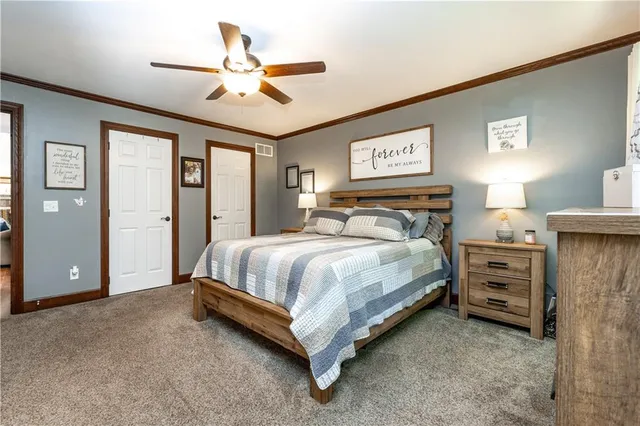 a bedroom with a bed a window and a flat screen television