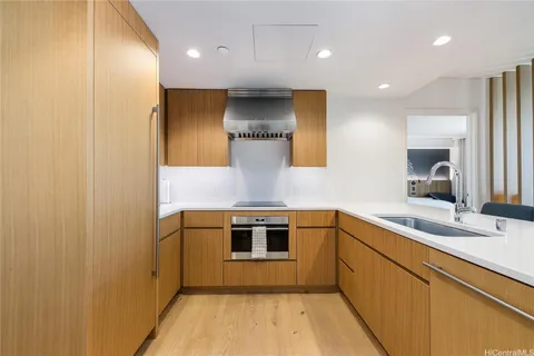 a kitchen with kitchen island a sink stainless steel appliances and cabinets