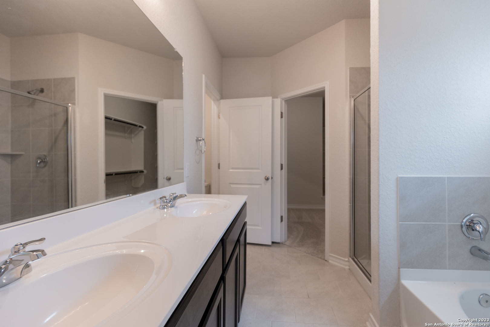 9819 Bratten Rise San Antonio, TX 78254 - Photo 15 of 37 a en suite bathroom with a tub sink and mirror