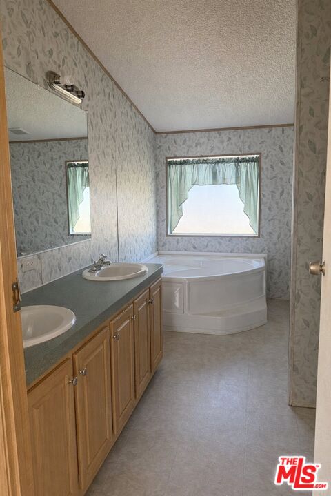 6288 Maricopa Road Phelan, CA 92371 - Photo 16 of 17 a bathroom with a granite countertop sink a mirror and a bathtub