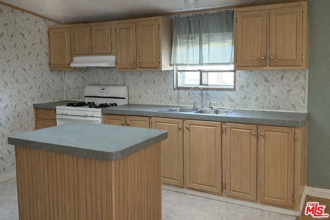 6288 Maricopa Road Phelan, CA 92371 - Photo 7 of 17 a kitchen with stainless steel appliances granite countertop a sink stove and cabinets