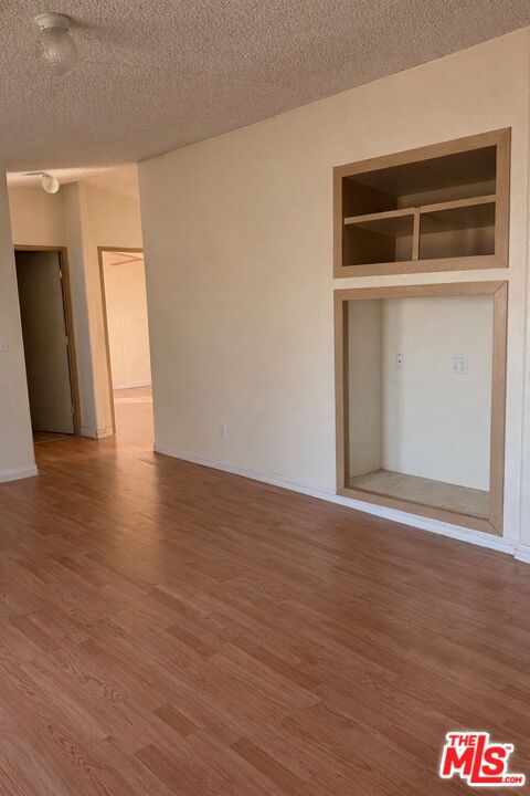 6288 Maricopa Road Phelan, CA 92371 - Photo 8 of 17 a view of an empty room with wooden floor and a window
