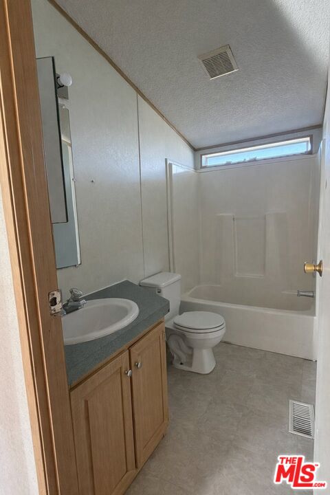 6288 Maricopa Road Phelan, CA 92371 - Photo 10 of 17 a bathroom with a granite countertop sink toilet a mirror and shower