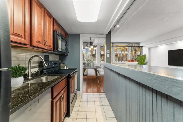 a kitchen with stainless steel appliances granite countertop a sink stove and cabinets