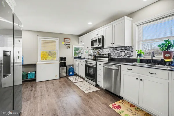 a kitchen with a white cabinets and wooden floor
