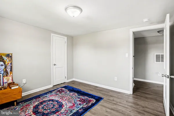 an empty room with wooden floor and furniture