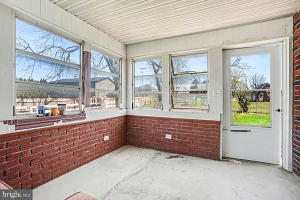 a area with wooden floor and windows