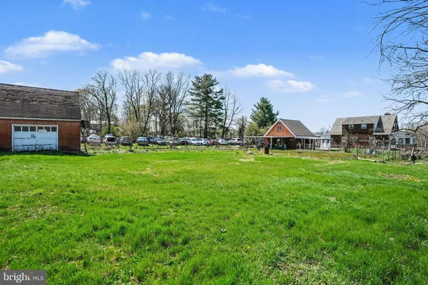 a view of a house with a big yard and large trees