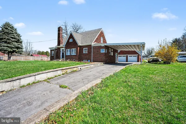 a view of a house with a big yard and large trees