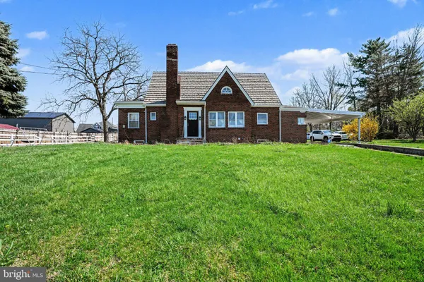 a view of a house with a big yard and large trees