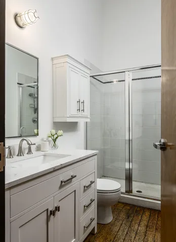 a bathroom with a granite countertop sink toilet a mirror and shower