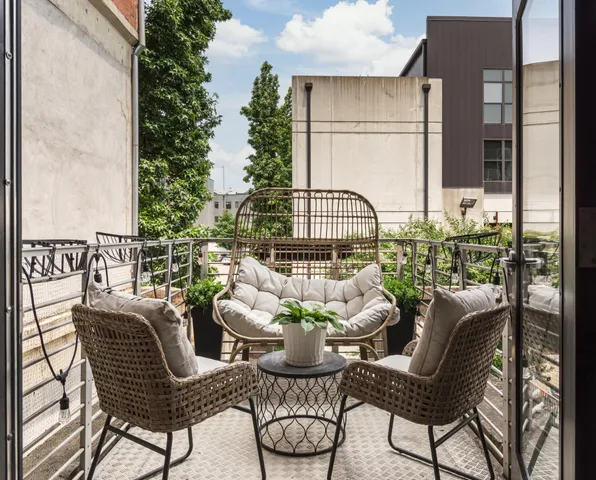 a view of a balcony with chairs and a potted plant