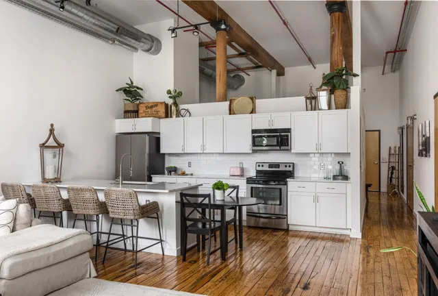 a kitchen with stainless steel appliances granite countertop a refrigerator and a stove top oven