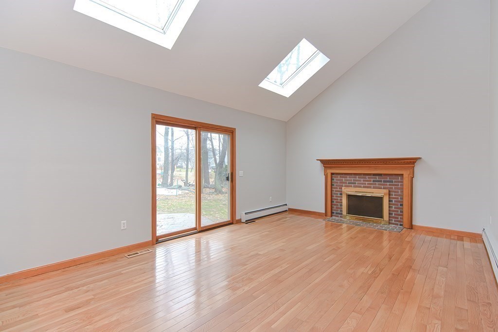 4 Bugli Lane Wakefield, MA 01880 - Photo 11 of 32 an empty room with wooden floor chandelier and windows