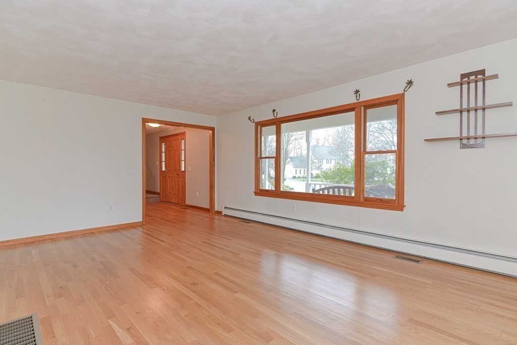 4 Bugli Lane Wakefield, MA 01880 - Photo 16 of 32 a view of an empty room with wooden floor and a window