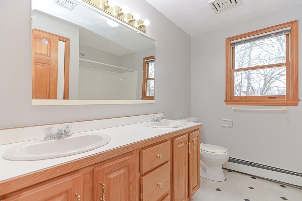 4 Bugli Lane Wakefield, MA 01880 - Photo 27 of 32 a bathroom with a sink a vanity and a toilet
