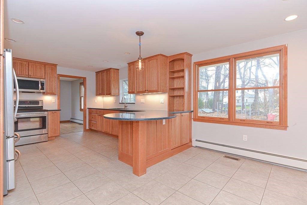 4 Bugli Lane Wakefield, MA 01880 - Photo 4 of 32 a kitchen with kitchen island granite countertop a sink counter top space cabinets and stainless steel appliances