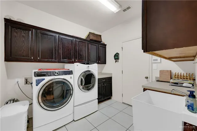a utility room with sink dryer and washer