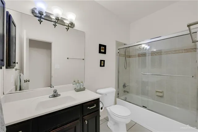 a bathroom with a sink a toilet a mirror and shower