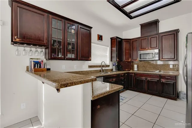 a kitchen with stainless steel appliances granite countertop a stove top oven a sink dishwasher and a refrigerator