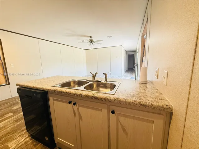 a view of kitchen with wooden floor and electronic appliances