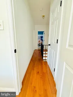 a view of a hallway with wooden floor and staircase