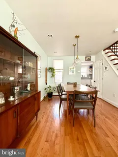 a living room with furniture a dining table and wooden floor