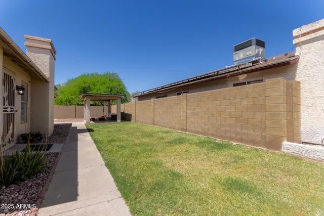 a backyard of a house with yard and wooden fence