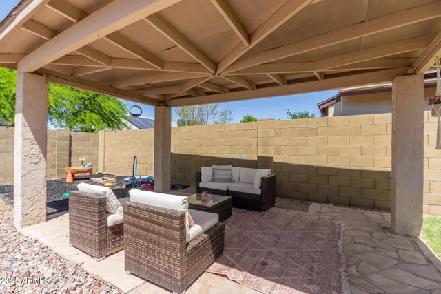 a backyard of a house with table and chairs