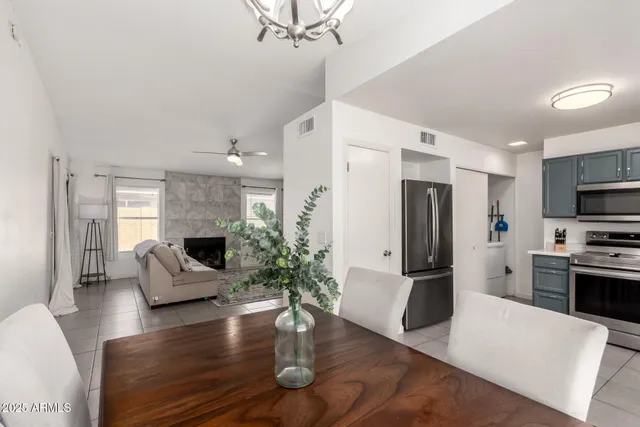 a kitchen with stainless steel appliances granite countertop a refrigerator a stove top oven a sink dishwasher and white cabinets with wooden floor