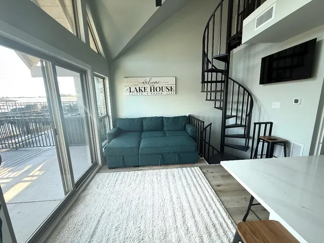 a view of a livingroom with furniture wooden floor and windows
