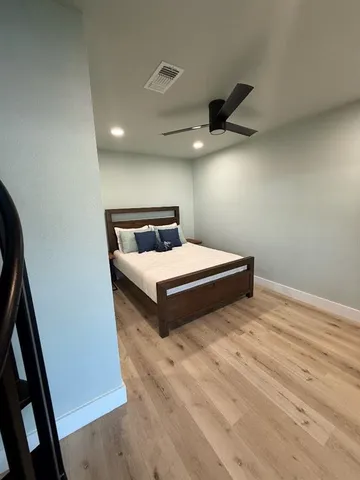 a bedroom with a bed and a ceiling fan