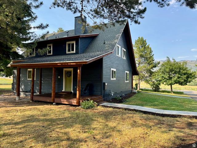 2807 North Ogden Canyon Road Eden, UT 84310 - Photo 2 of 72 Two-story residence featuring dark siding, a covered front porch with natural wood posts, and a prominent chimney