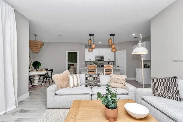 a living room with furniture and a dining table with kitchen view