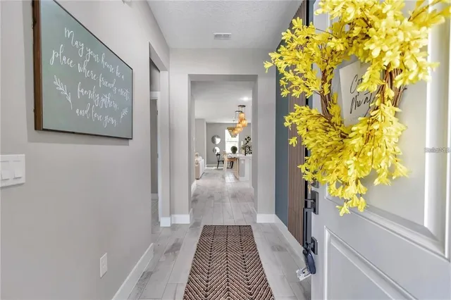 a hallway with wooden floor and a potted plant