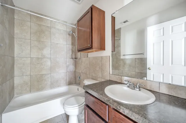 a bathroom with a granite countertop sink toilet and shower
