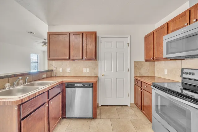 a kitchen with stainless steel appliances granite countertop a sink stove and cabinets