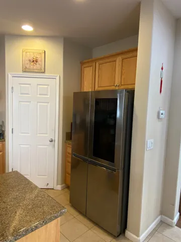 a kitchen with stainless steel appliances granite countertop a stove a sink a microwave a refrigerator a dining table and chairs with wooden floor