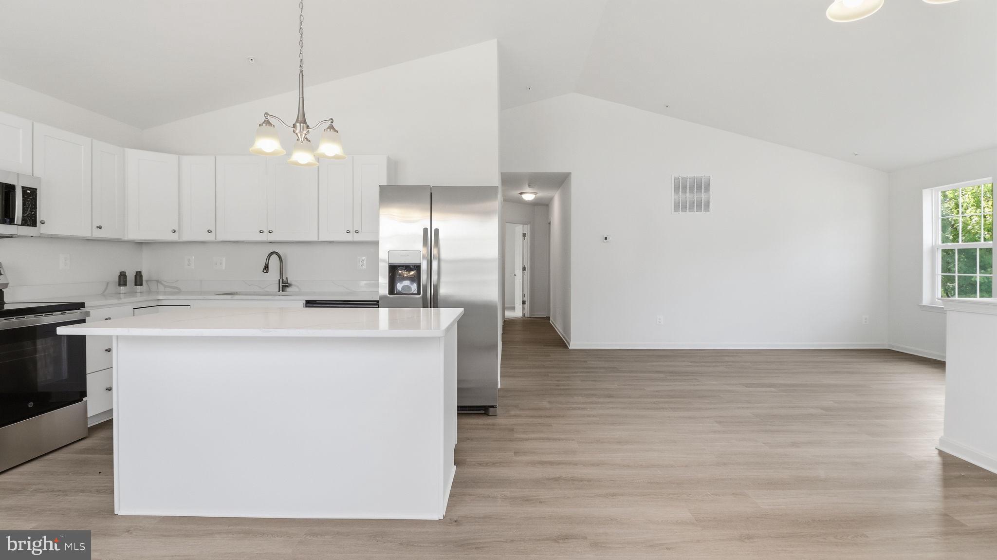 7349 Hughes Avenue Sparrows Point, MD 21219 - Photo 29 of 38 a kitchen with kitchen island a sink a center island stainless steel appliances and a window