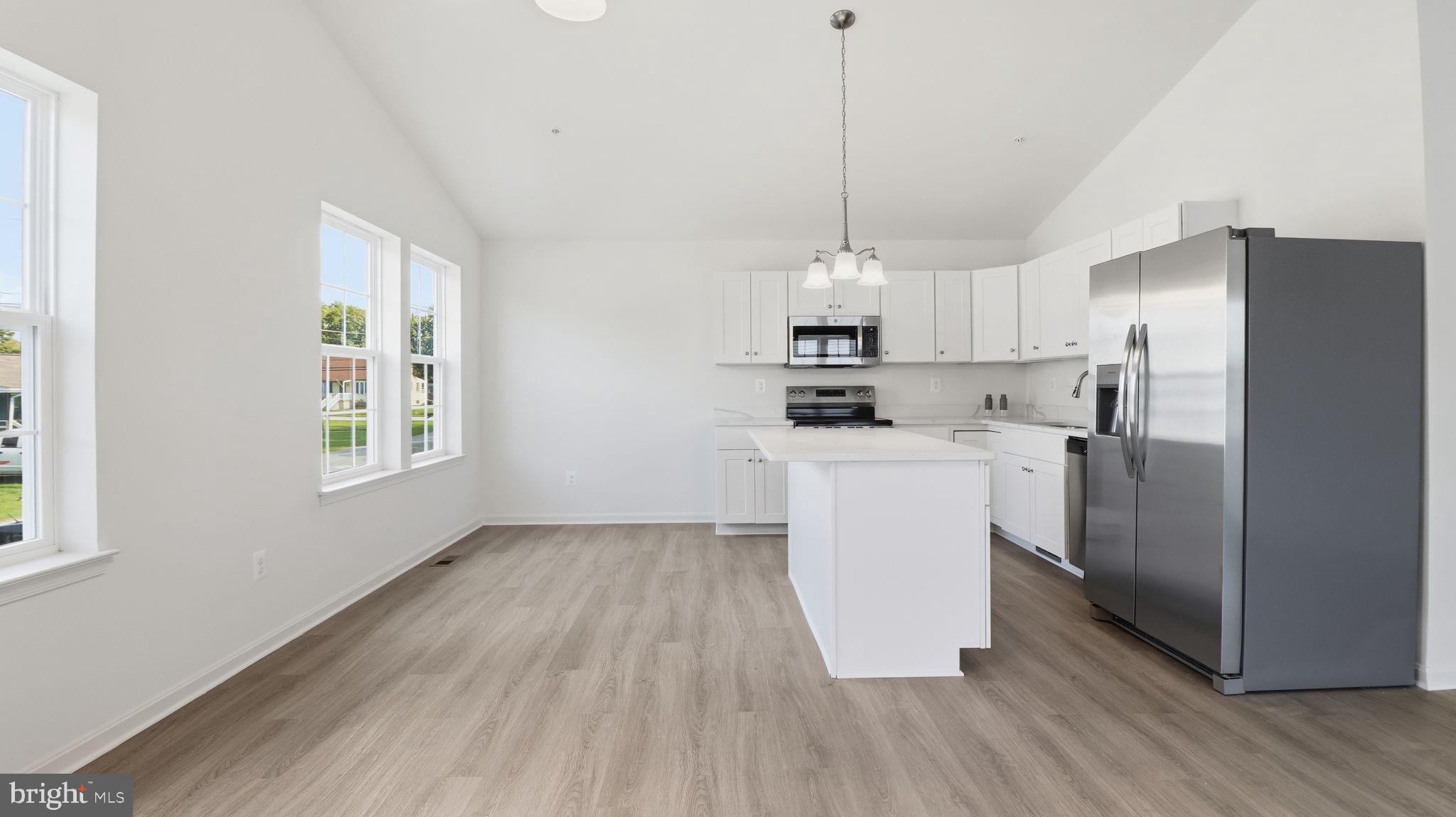 7349 Hughes Avenue Sparrows Point, MD 21219 - Photo 31 of 38 a kitchen with kitchen island white cabinets stainless steel appliances a sink and a window