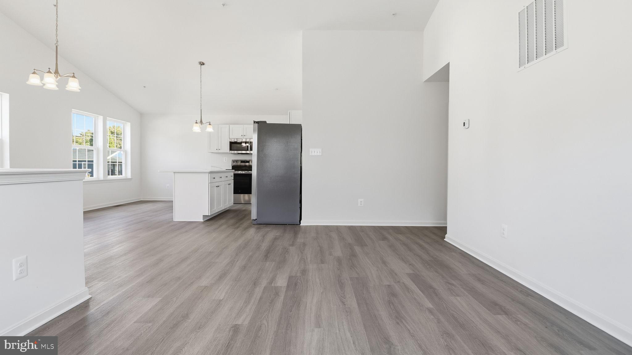 7349 Hughes Avenue Sparrows Point, MD 21219 - Photo 34 of 38 a view of a kitchen with refrigerator and wooden floor