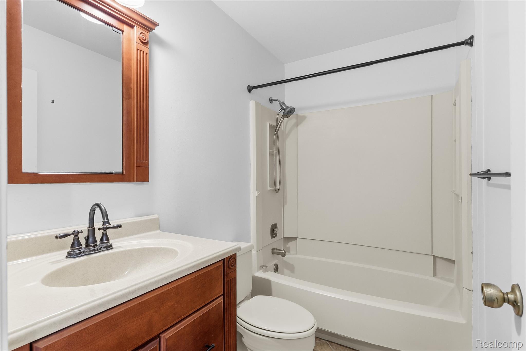 9200 Hickory Ridge Road Holly, MI 48442 - Photo 20 of 33 Bathroom featuring a wood vanity with a light-colored countertop, an integrated sink, and an oil-rubbed bronze faucet