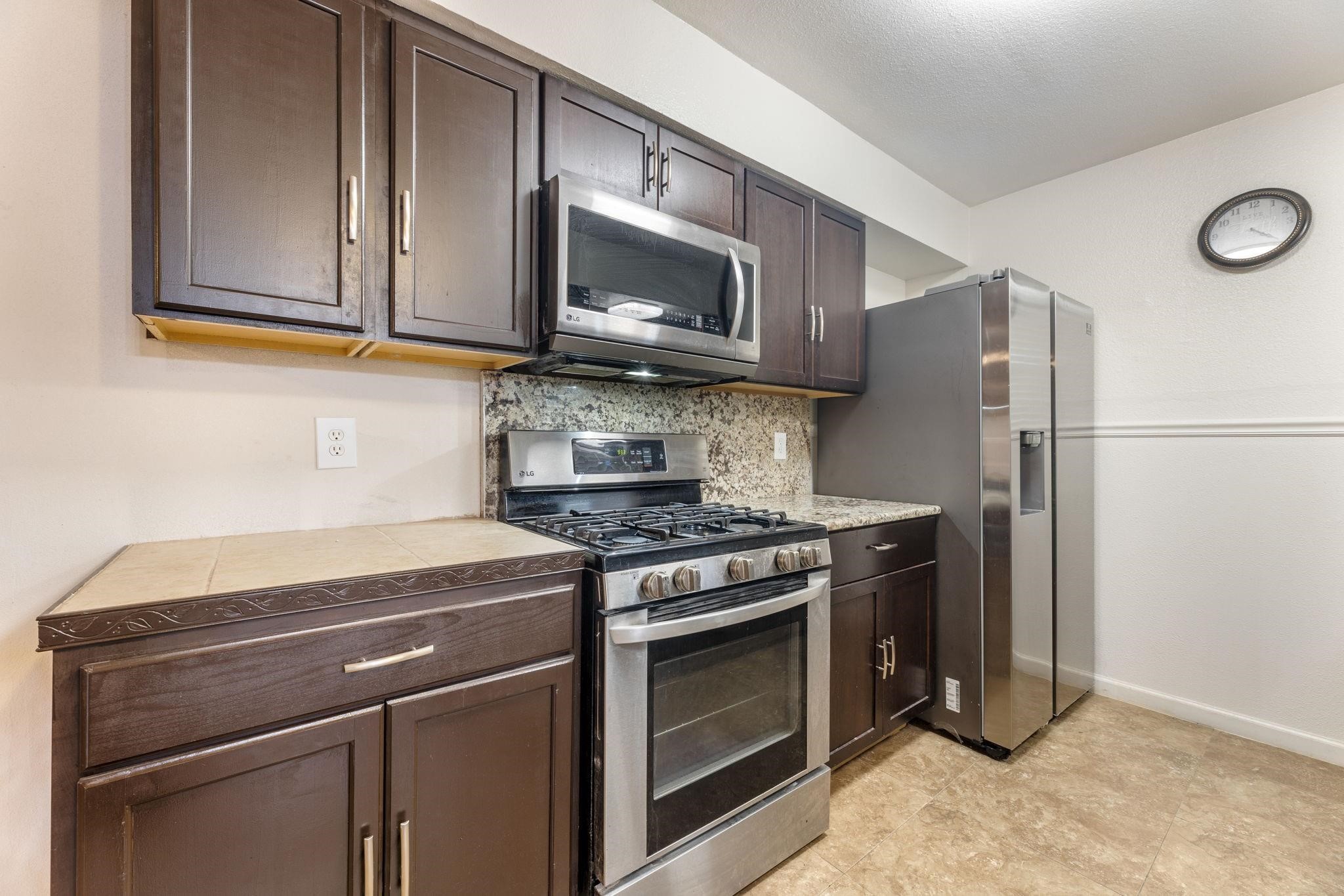 3606 Balmorhea Avenue Houston, TX 77039 - Photo 7 of 21 a kitchen with stainless steel appliances granite countertop a stove microwave and refrigerator