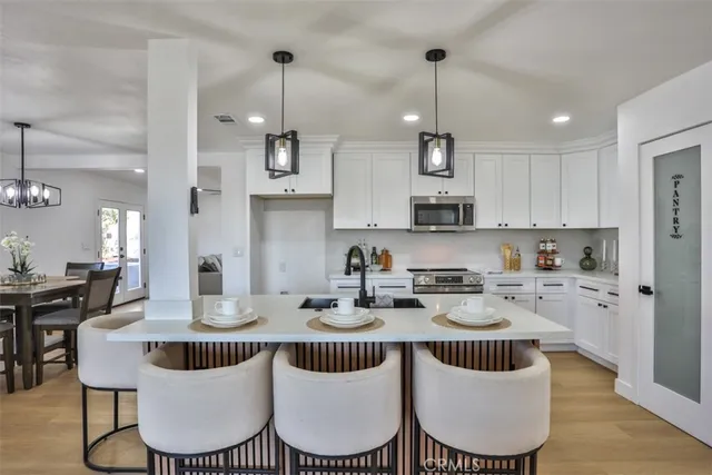 a kitchen with stainless steel appliances granite countertop a kitchen island a table and chairs