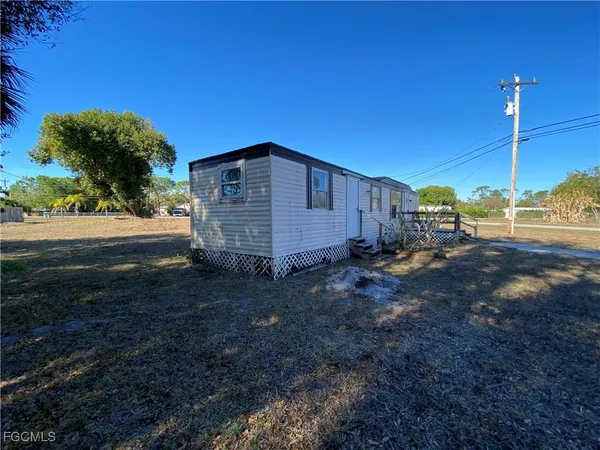 a view of a house with backyard and trees