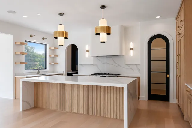 a large kitchen with lot of cabinets and wooden floor