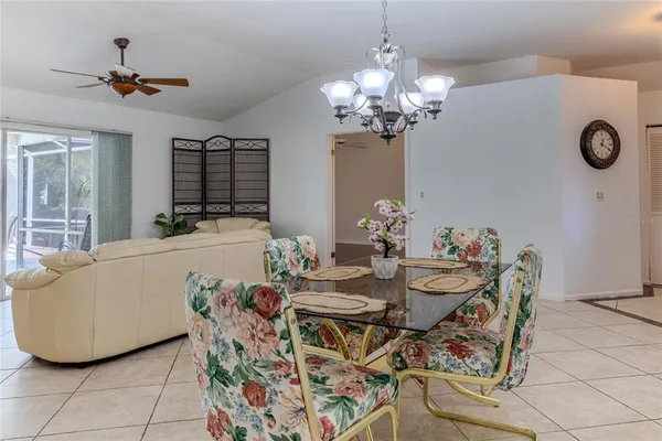 a living room with a dining table and a chandelier