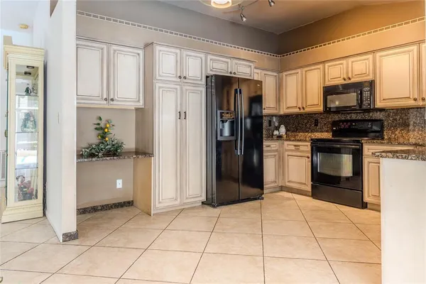 a kitchen with stainless steel appliances granite countertop a refrigerator and a sink